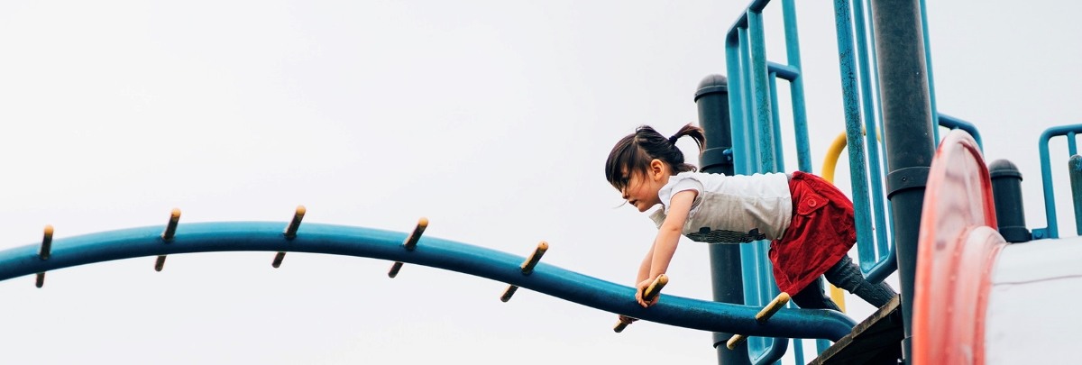3 year old girl playing with playground equipment